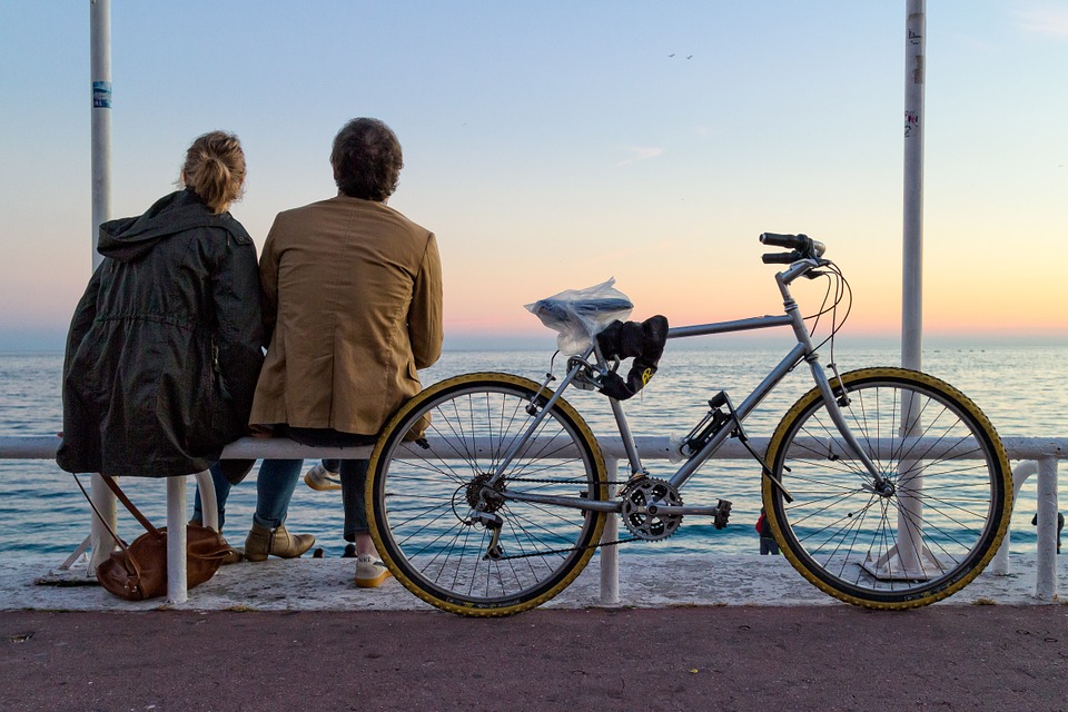 Par ser på solnedgang med cykel i baggrunden